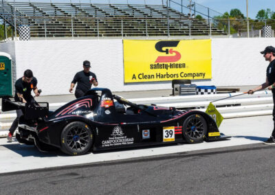 A pit crew performing maintenance on Team Earle’s #39 Radical SR3 XX, painted black
