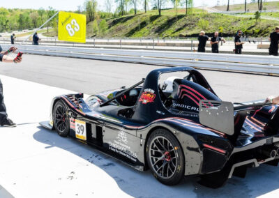A pit crew finishing maintenance on Team Earle’s #39 Radical SR3 XX, painted black