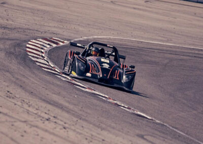 Team Earle’s #39 Radical SR3 XX, painted black, taking a turn on a motor speedway