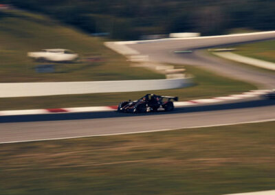 A wide shot of Team Earle’s #39 Radical SR3 XX, painted black and travelling at a high speed down an otherwise empty track